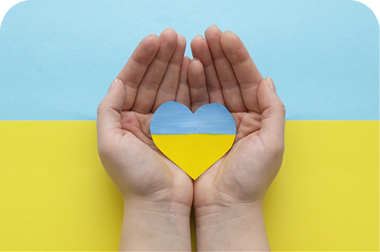 Hands holding a heart in the colours of the Ukrainian flag.